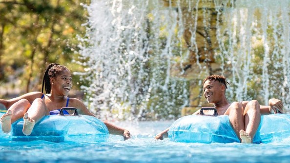 People on rafts going through waterfall 