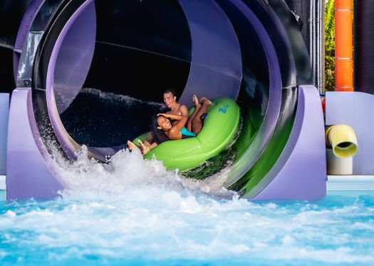 Family hugging and having fun in wavepool 